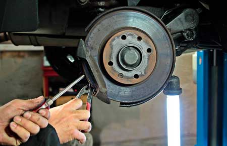 man repairing heavy duty truck braking system